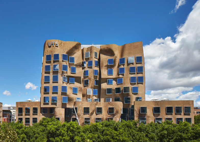 A modern building with a unique, undulating brown brick facade and square windows.