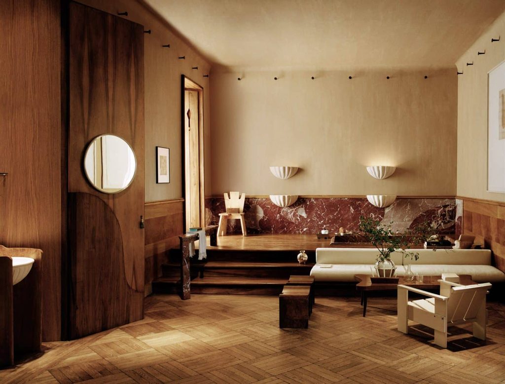 Warm, rustic-modern space with rich wood paneling, parquet flooring, reddish marble trim, shell-shaped wall sconces, and low-slung seating, best interior designers in Paris