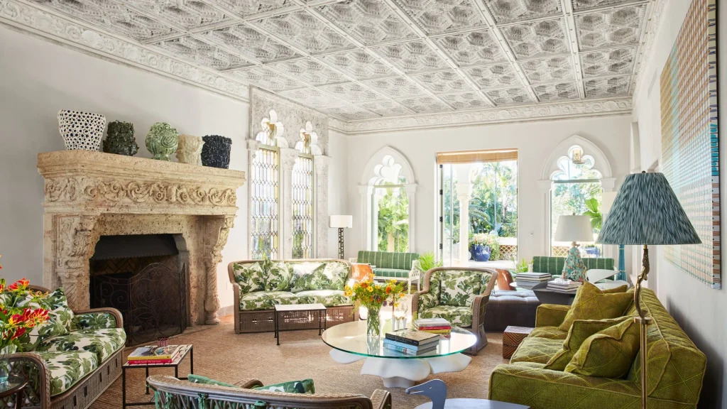 High-ceilinged hall with classic wall moldings, black-and-white checkered floor, curved dark blue leather banquettes, and tall window openings, best interior designers in Paris