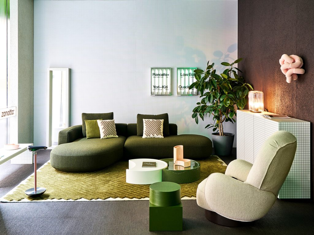 Contemporary interior display featuring an olive green curved sectional sofa, a light cream armchair, and grid-patterned walls. top interior design firms in milan