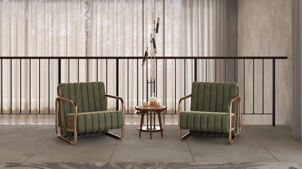 "Two green channel-tufted Minelli armchairs with brass frames flanking a side table by a window."